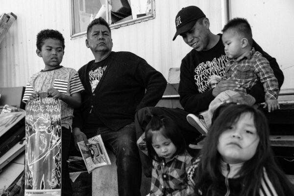 A group of people sitting on the ground with children.