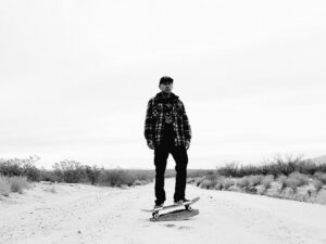 A man riding a skateboard down the middle of a road.