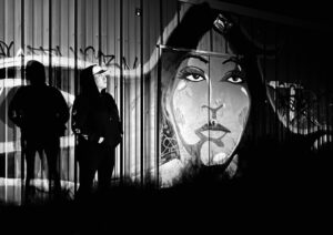 A black and white photo of people standing in front of a wall.