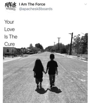 Two people holding hands while walking down a street.