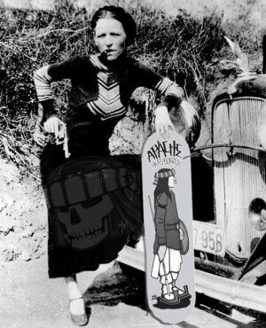 A woman holding a skateboard in front of an old truck.