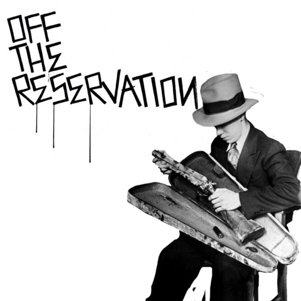 A man in a hat and suit playing an electric guitar.
