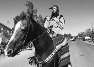 A person on horseback riding down the street.