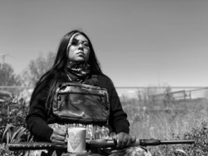 A woman holding a rifle in her hands.