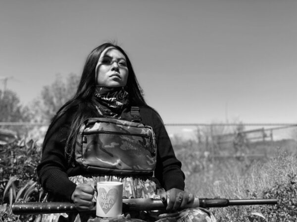 A woman holding a rifle in her hands.