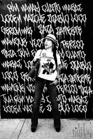 A person standing in front of graffiti on the wall.
