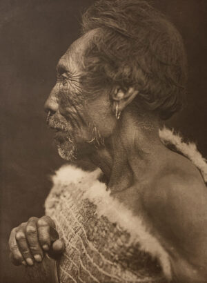 A woman with her hands clasped in front of her face.