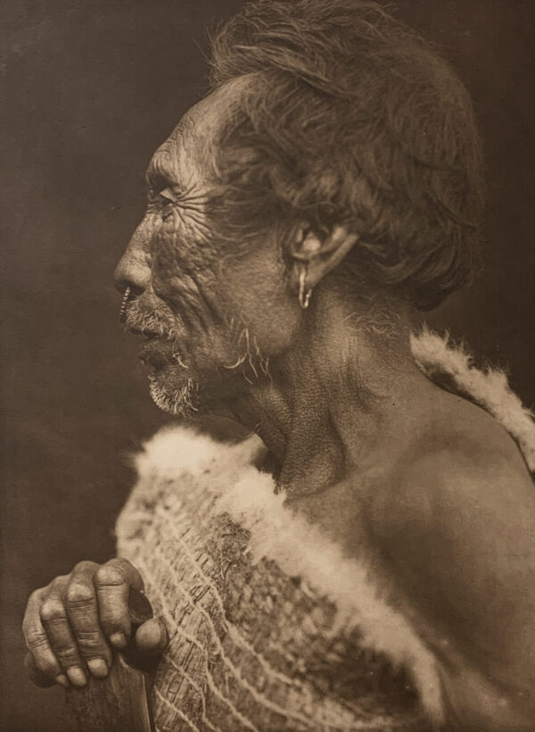 A woman with her hands clasped in front of her face.