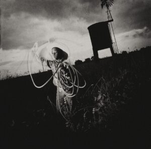 A woman holding onto a rope in the middle of a field.