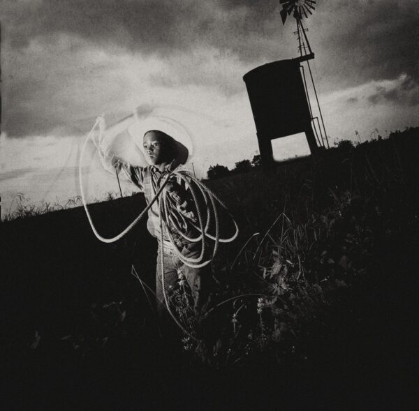 A woman holding onto a rope in the middle of a field.