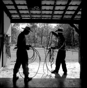 Two men holding a bunch of ropes in their hands.