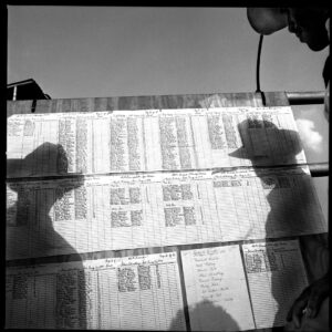 A black and white photo of people looking at the wall.