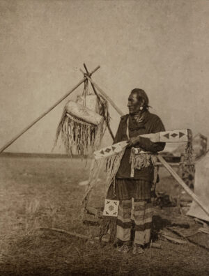 A man standing in front of an indian tent.