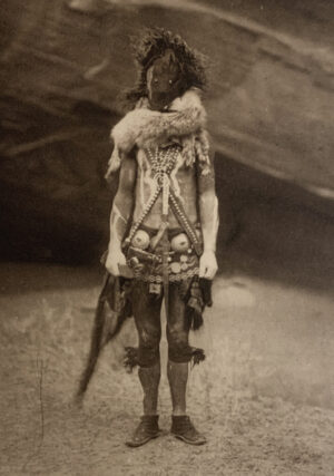 A man in native dress standing on the ground.