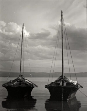 Two boats in the water with a cloudy sky above.