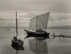 A boat is sailing in the water near other boats.
