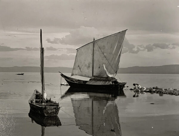 A boat is sailing in the water near other boats.