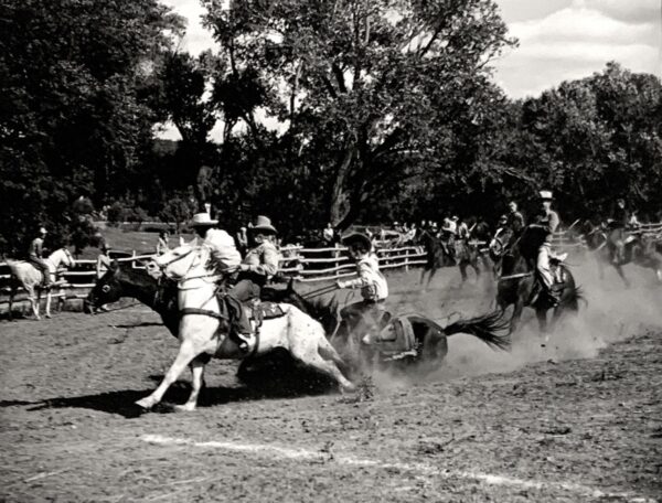 A group of men riding horses in the dirt.
