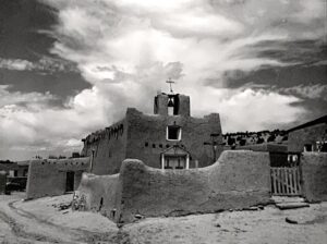 A black and white photo of an adobe church.