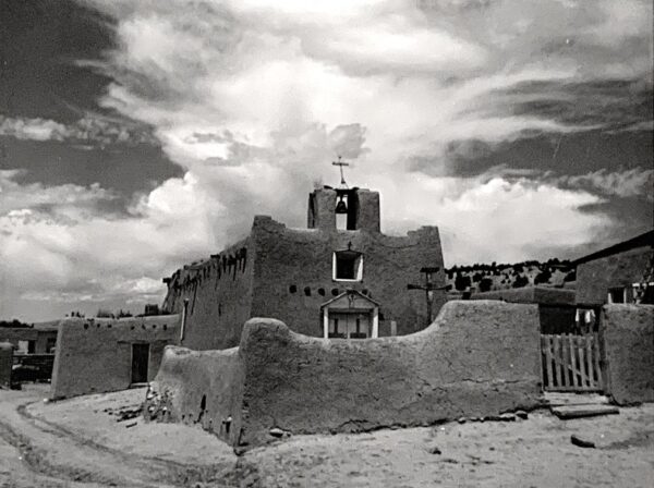 A black and white photo of an adobe church.