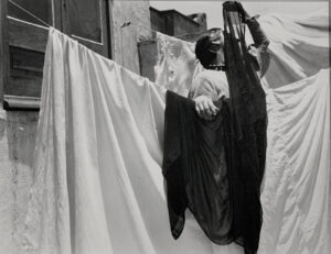 A woman hanging clothes on the line outside