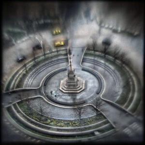 A circular fountain with a statue in the middle of it.