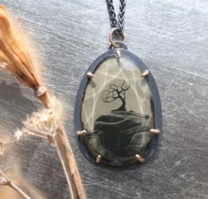 A necklace with a picture of a tree on it.