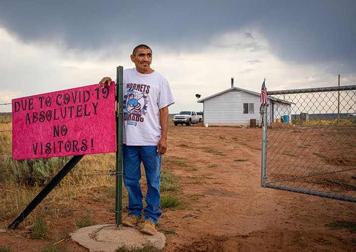 Man standing by "No Visitors" sign.