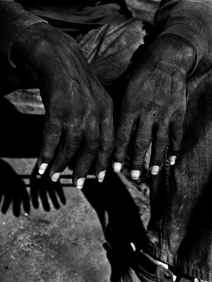 A black and white photo of two hands with nails.