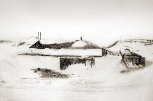 A black and white photo of some buildings in the snow.