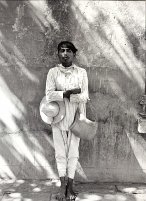 A man in white shirt holding two hats.