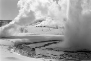 A black and white photo of steam coming out from the ground.