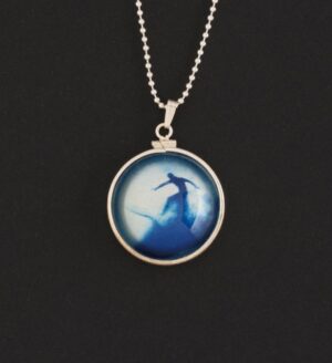 A silver necklace with a picture of a surfer.