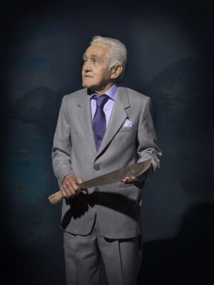 A man in a suit holding a baseball bat.