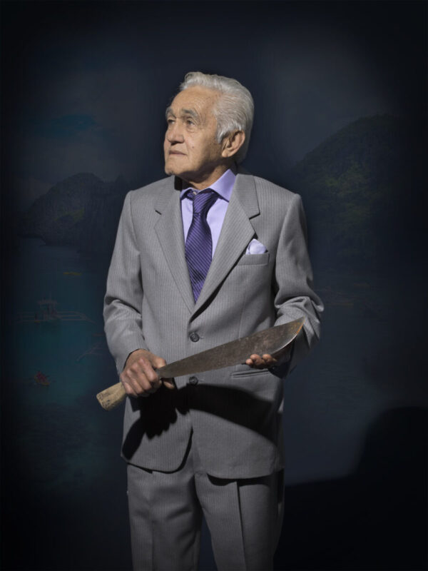 A man in a suit holding a baseball bat.