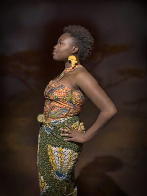 A woman in an african print outfit posing for the camera.