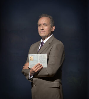 A man in suit and tie holding an envelope.