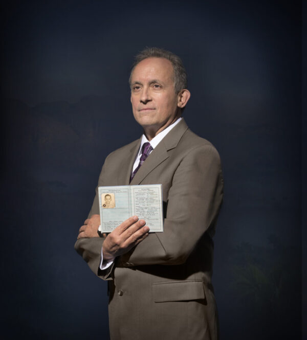 A man in suit and tie holding an envelope.