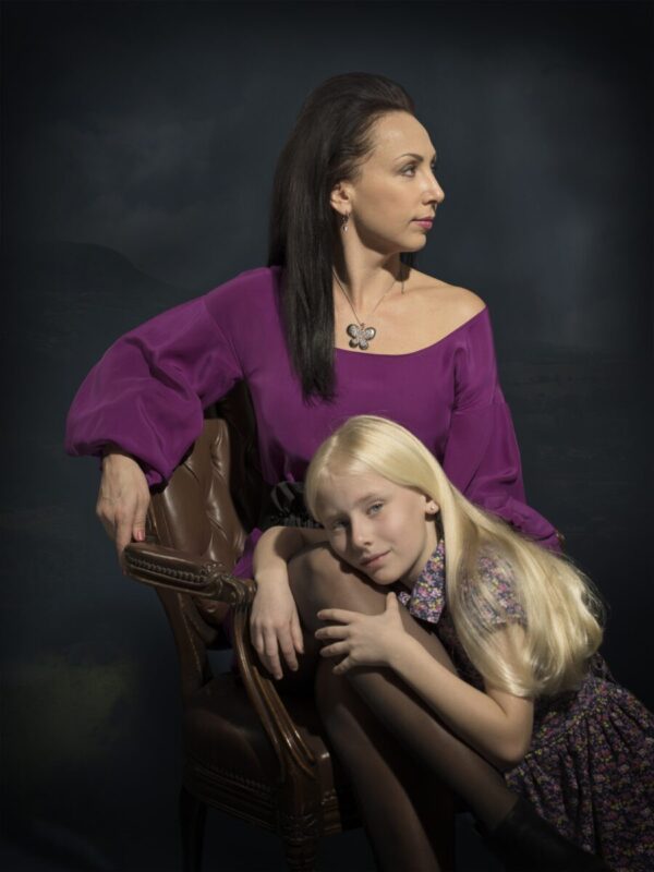 A woman and girl sitting on a chair