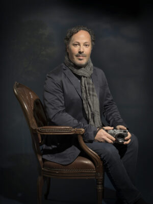 A man sitting in a chair holding a camera.