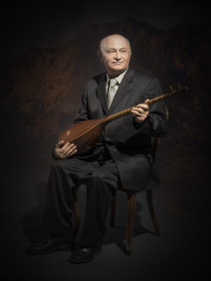 A man in a suit and tie holding an instrument.