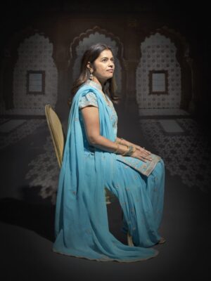 A woman in blue sitting on a chair
