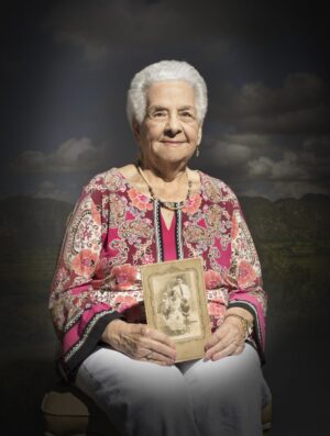 A woman holding an old picture in her hands.