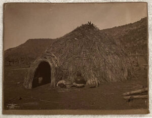 A hut made of straw and grass in the desert.