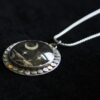 A necklace with a black and white moon on it.