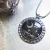 A necklace with a black and silver pendant on it