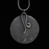 A necklace with a metal disc and a wire loop.