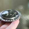 A person holding onto a silver ring with a picture of the moon.