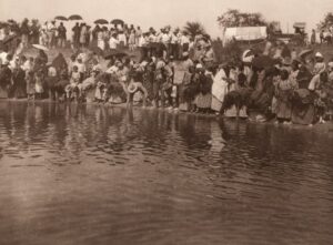 A group of people standing on top of a body of water.