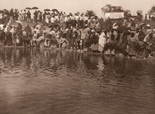 A group of people standing on top of a body of water.